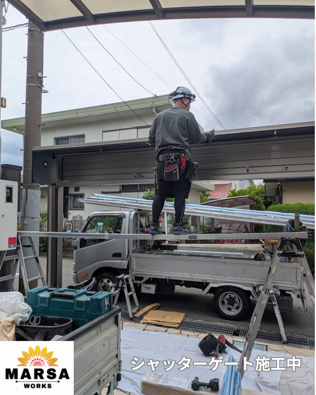 シャッターゲート本体を取り付けている外構職人の作業風景