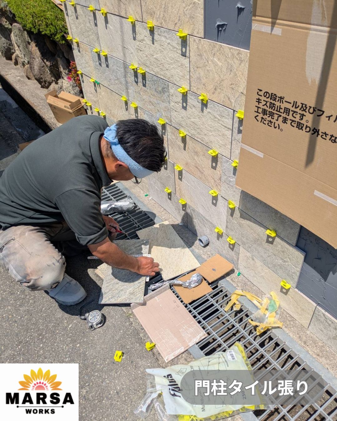 尼崎市の造作門柱へ石目調タイルを施工している職人
