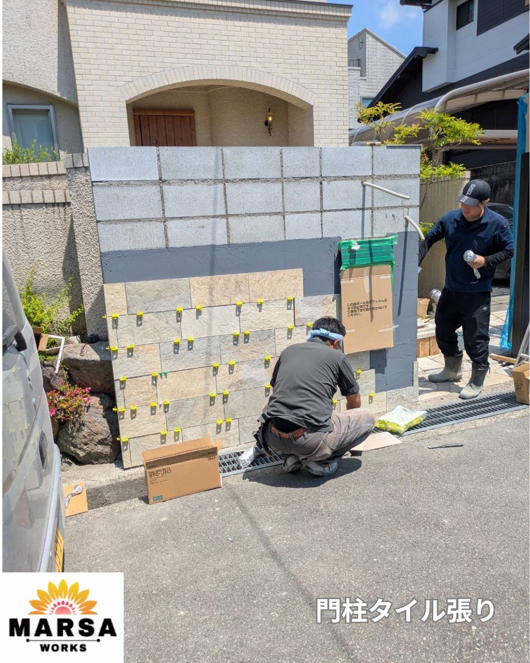 石目調タイルを造作門柱へ張り付けている外構工事の様子
